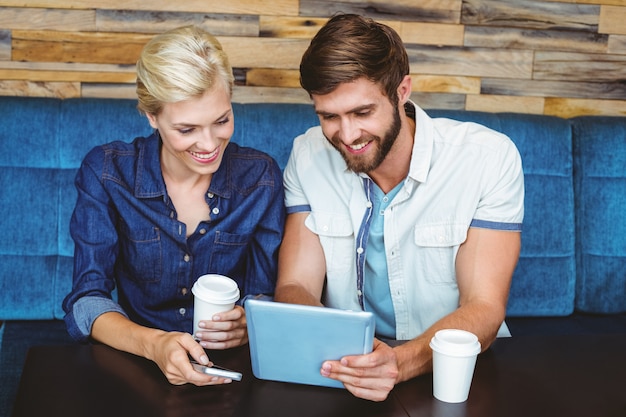 Casal bonito em uma data assistindo fotos em um tablet