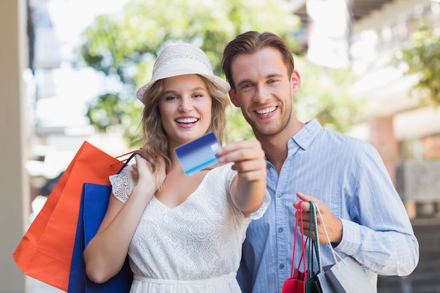 Casal bonito mostrando um cartão de crédito