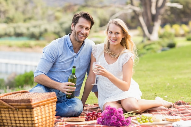 Casal bonito na hora de derramar vinho em um copo