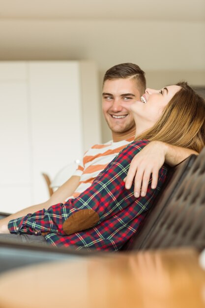 Casal bonito relaxando no sofá assistindo TV