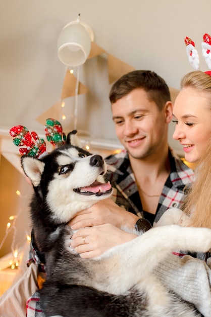 Casal brincando com cachorro no quarto