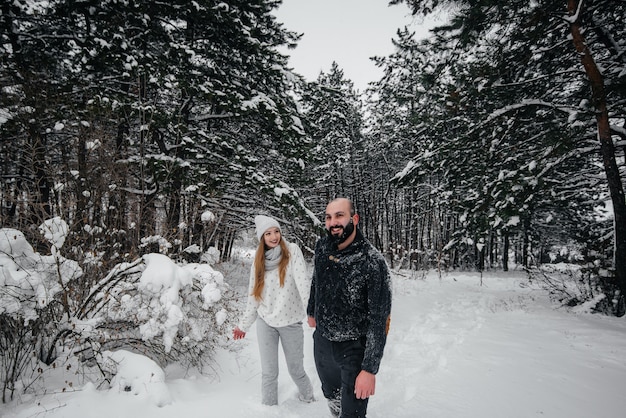 Casal brincando com neve na floresta