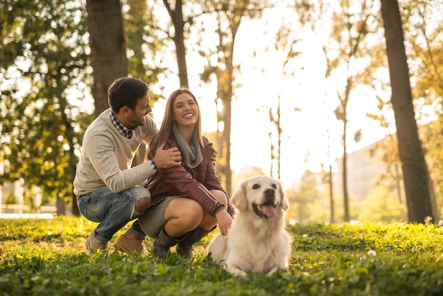 Casal brincando com seu cachorro no parque