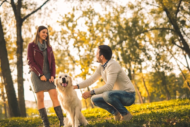 Casal brincando com seu cachorro no parque