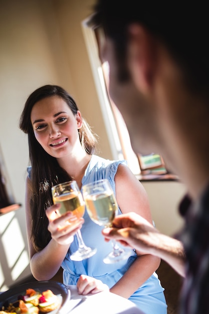 Casal brindando o copo de vinho branco no restaurante