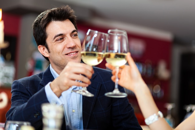 Casal brindando taças de vinho em um restaurante