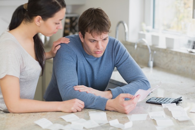 Casal calculando contas na cozinha