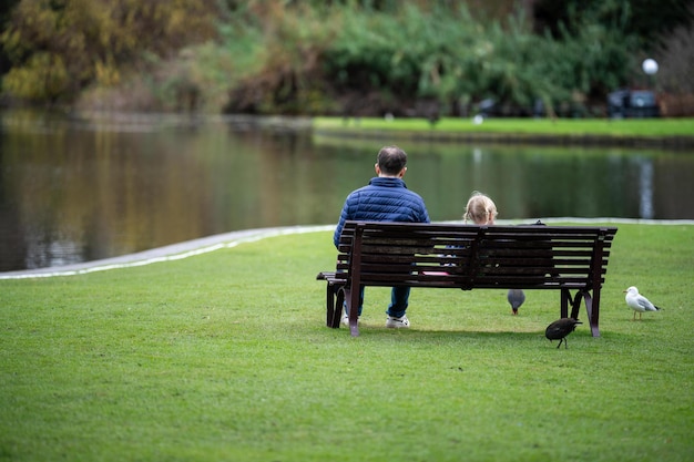 Casal caminhando em um jardim, homem e mulher caminham na natureza sob árvores cercadas por plantas familiares juntas em um parque na primavera