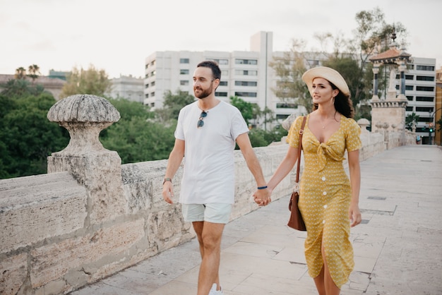 casal caminhando sobre a antiga ponte na velha cidade de Espanha. Um casal de turistas em um encontro em Valência