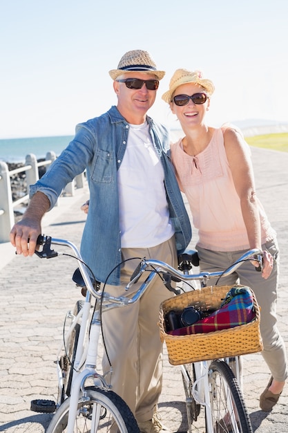 Casal casual feliz indo para um passeio de bicicleta no cais