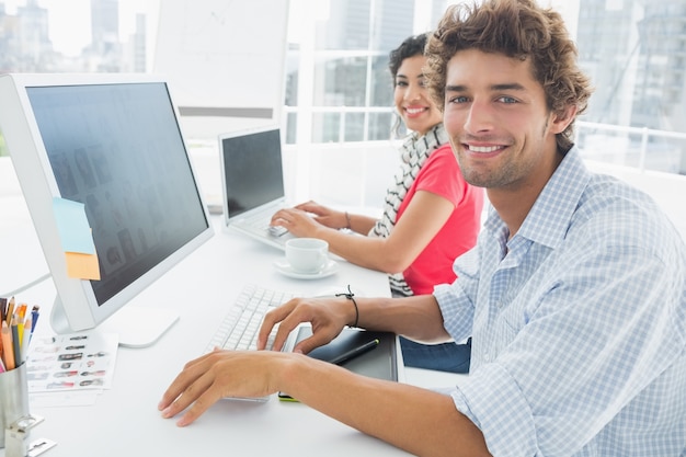 Casal casual usando computadores no escritório