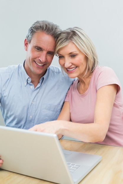 Casal casual usando laptop em casa