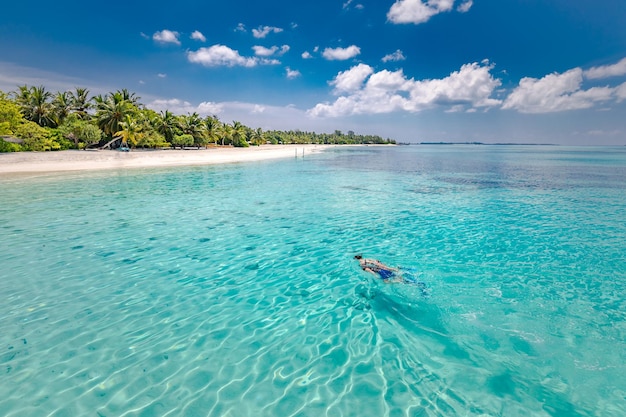 Casal caucasiano de turistas mergulha na água turquesa cristalina perto da Ilha Maldivas. Baía do oceano azul