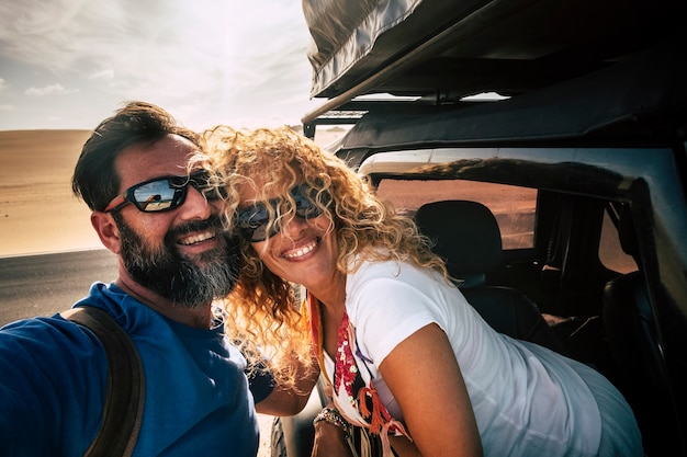 Foto casal caucasiano feliz adulto alegre viaja de carro e tira uma foto de selfie sorrindo junto com amizade e relacionamento