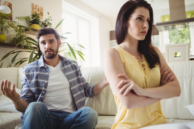 Casal chateado discutindo uns com os outros no sofá