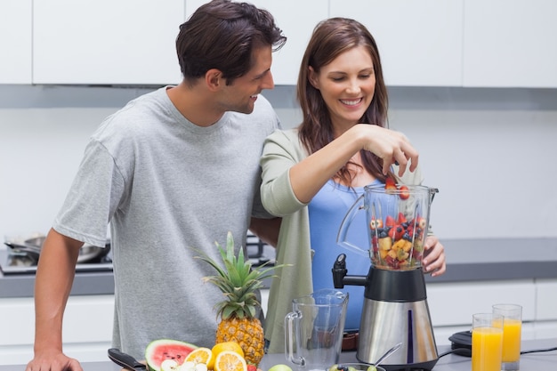 Casal colocando frutas no liquidificador