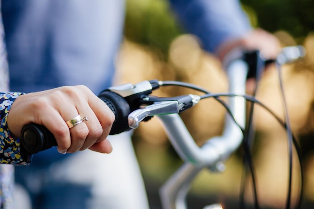 Casal com bicicleta tandem noivado e anel de casamento close-up