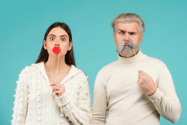 Casal com bigode e lábios falsos. Se divertindo. Conceito de cabine fotográfica. Casal se divertindo com bigode e lábios falsos.