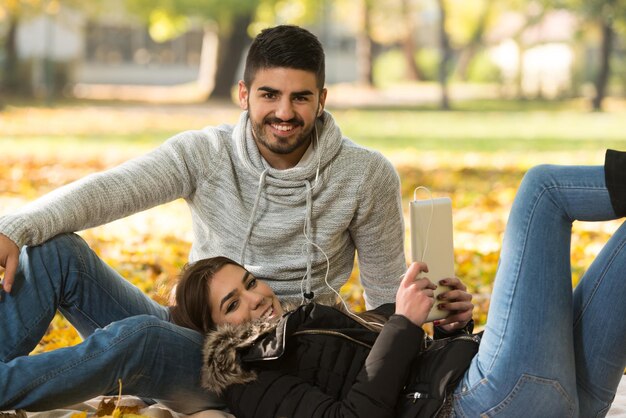 Casal com fones de ouvido curtindo música no dia de outono