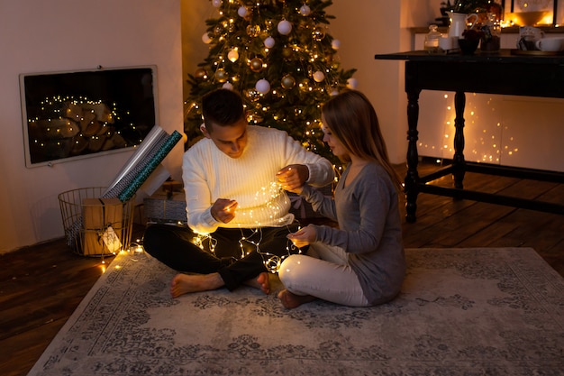 Casal com guirlanda de natal nas mãos