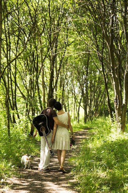 Casal com guitarra andando no parque