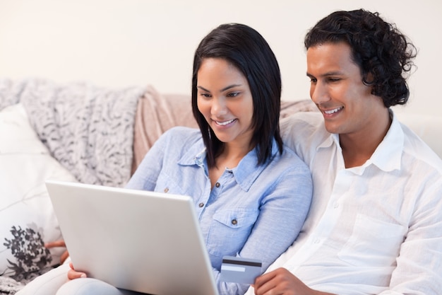 Casal com laptop no sofá