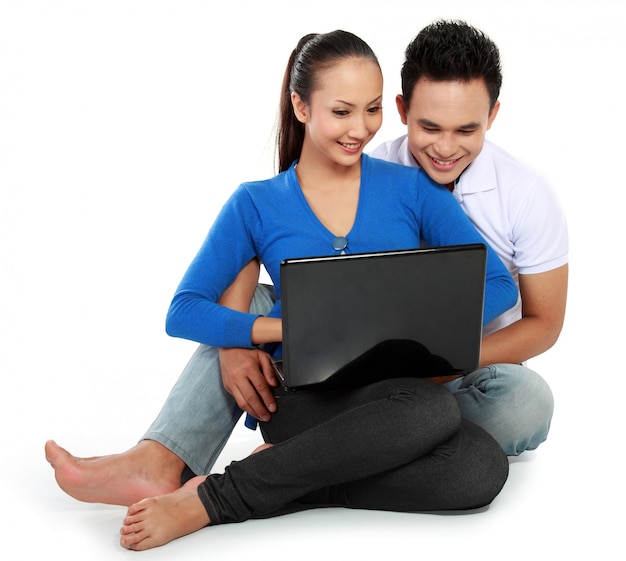 Casal com laptop, sentada no chão