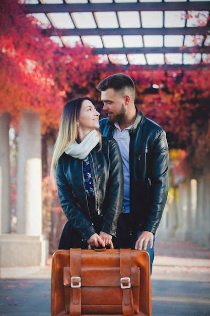 casal com mala no beco no outono temporada