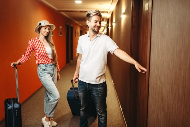 Casal com malas procurando seu quarto de hotel