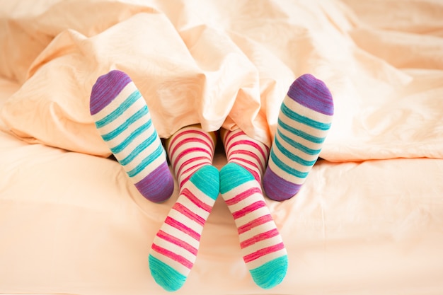Foto casal com meias de natal no quarto