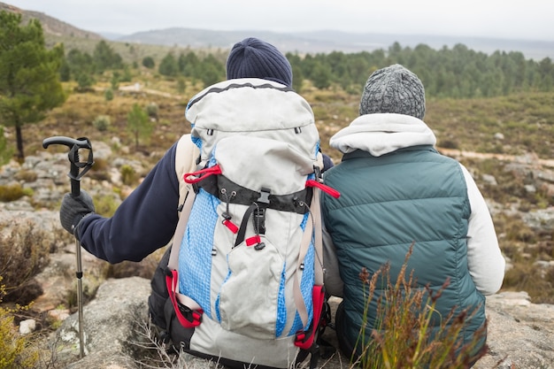 Casal com mochila e trekking pole em uma caminhada