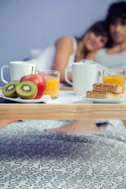 Foto casal com pequeno-almoço na cama em casa