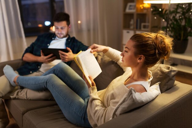 Foto casal com tablet e livro em casa