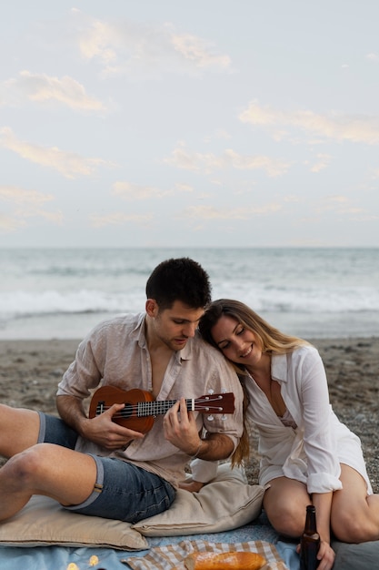 Foto casal com ukulele juntos na praia