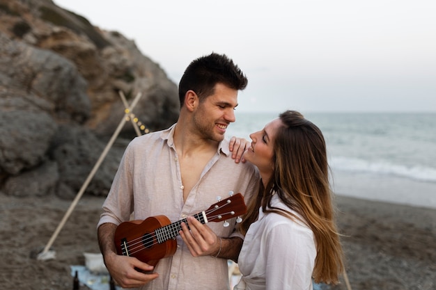 Foto casal com ukulele juntos na praia