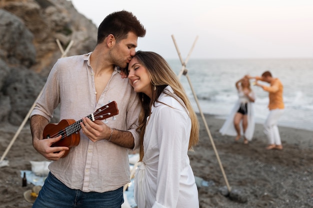 Casal com ukulele juntos na praia