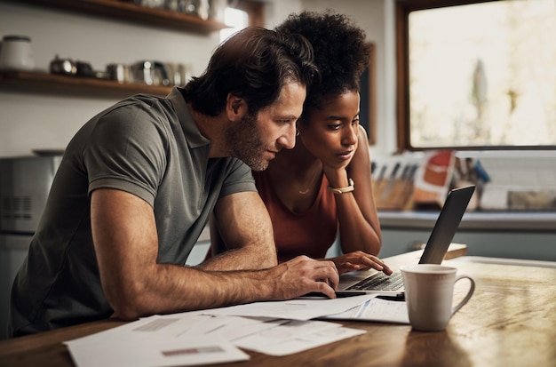 Foto casal com um laptop fazendo papelada financeira pagando empréstimos de seguro de dívida ou ebanking on-line juntos em casa duas pessoas sérias planejando e analisando a taxa de contas de documentos financeiros para hipoteca