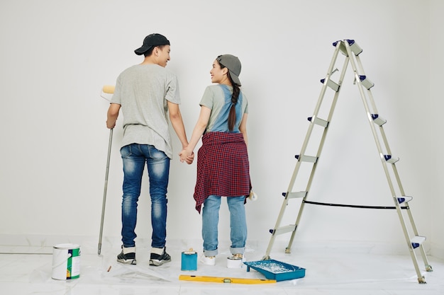 Casal começando a pintar parede