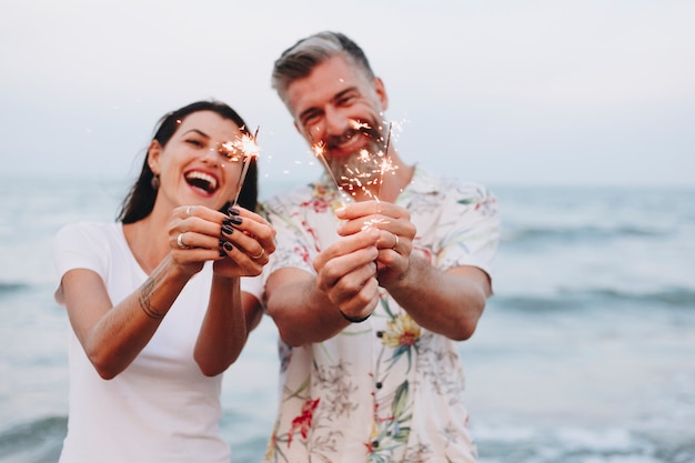 Casal comemorando com fogos de artifício na praia