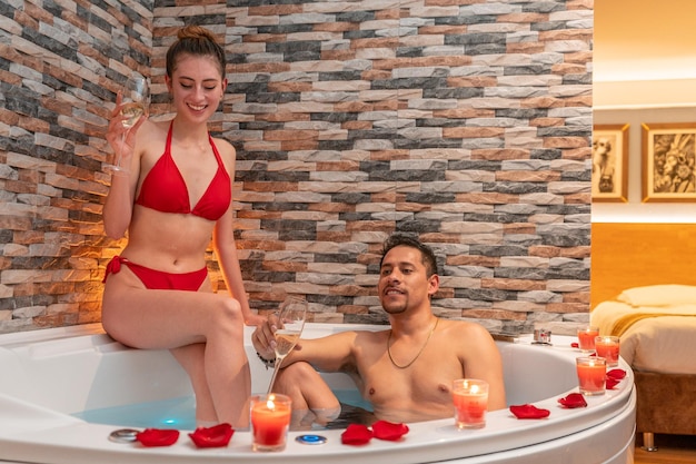 Casal comemorando uma noite romântica para o dia dos namorados em um hotel com jacuzzi.