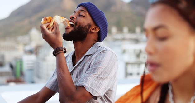 Casal comendo pizza e se unindo no telhado do prédio da cidade em Miami, Flórida, enquanto dança, desfruta e relaxa Sorria, homem e mulher negros felizes com fast food em um local turístico relaxante para o verão