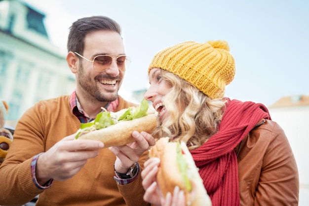 Casal comendo sanduíche