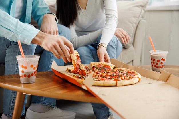 Casal compartilhando pizza e comendo