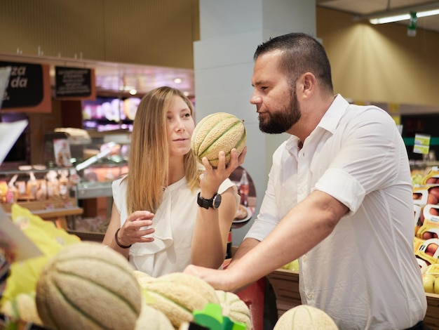Casal compra frutas no supermercado