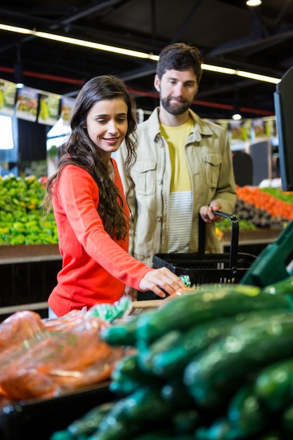 Foto casal comprando legumes na loja orgânica