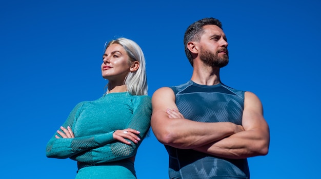 Casal confiante de esporte. homem musculoso e mulher sexy em roupas esportivas. os atletas sentem sucesso. instrutor e treinador de fitness. cara e mulher relaxam após o treino ao ar livre. moda esportiva.