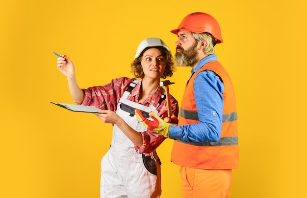 Casal construtor de parcerias olha para casa casal de planos olhando para uma planta de mulher e homem