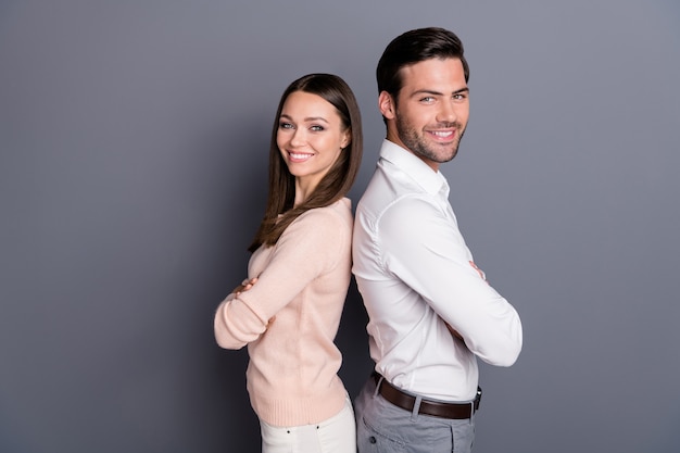 casal corporativo homem mulher cruzou os braços posando na parede cinza