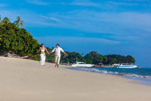 Casal correndo em uma praia tropical