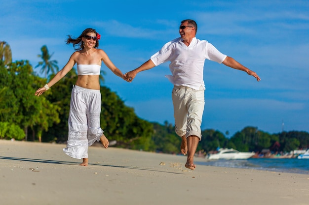 Casal correndo em uma praia tropical